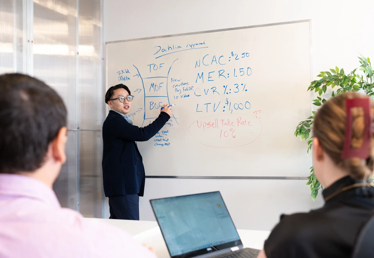 Chaky Ling presenting ecommerce growth metrics at a whiteboard to the team